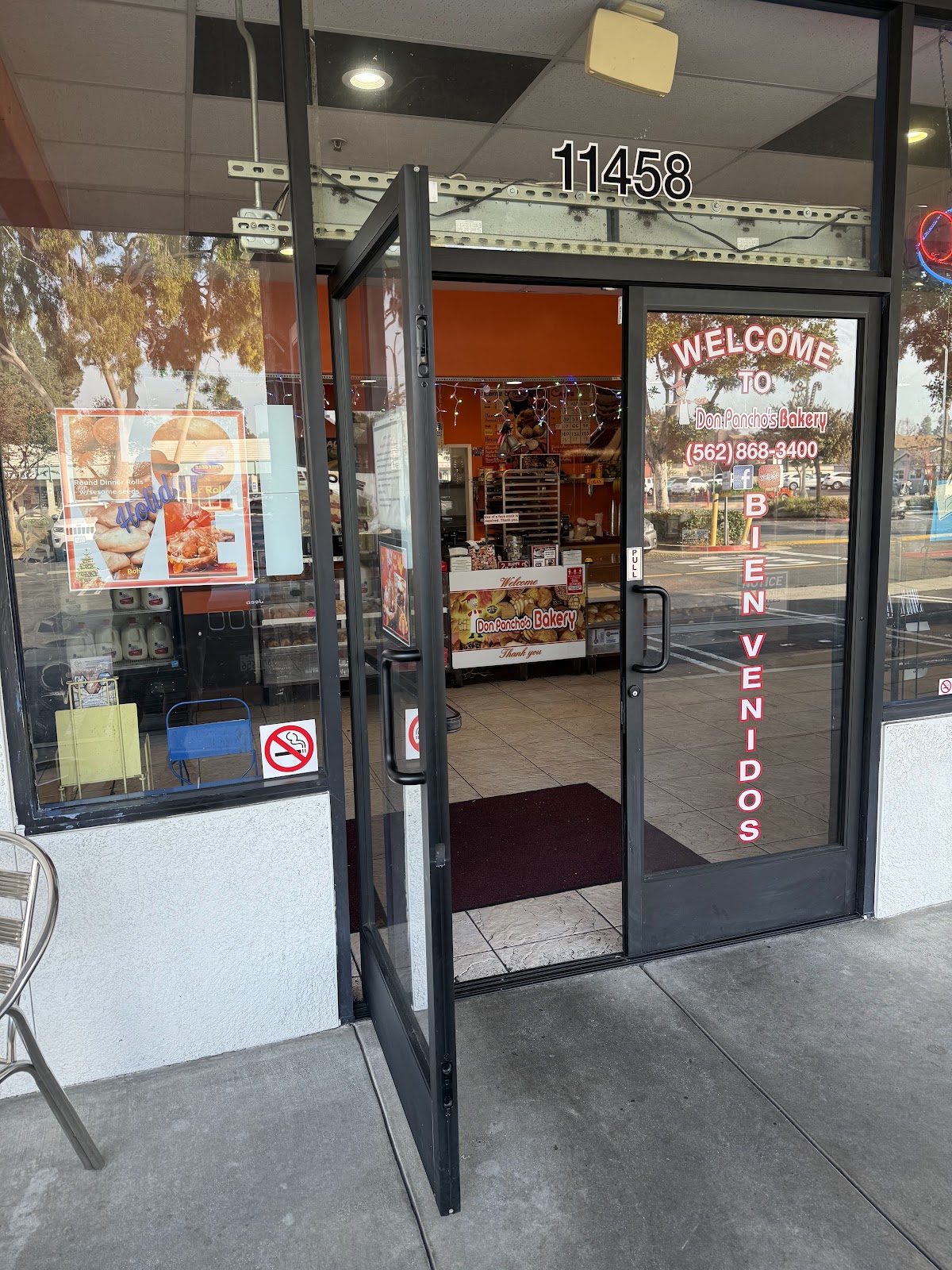 The front door of Don Pancho's Bakery with its welcome decal and phone number